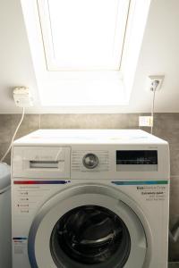 a washing machine in a room with a window at DINBNB Apartments l 100m to Bryggen l Pet Friendly l Sleeps 4 l Smart-TV in Bergen +6 photos