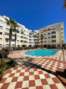 a large building with a pool in front of a resort at Arena beach in Martil