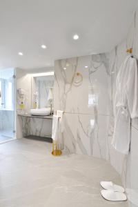 a white bathroom with a marble wall at Acropolian Spirit Boutique Hotel in Athens