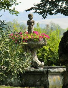 a statue in a garden with pink flowers at Villa Pona in San Salvatore Monferrato +10 photos
