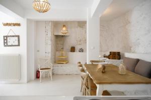a living room with a wooden table and chairs at Terramare Villa's 3 in Kithnos