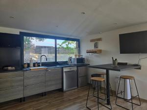 a kitchen with a sink and a counter with stools at studio de charme in Montbazin