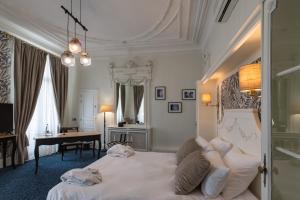 a bedroom with a bed and a desk in a room at Oceania Hôtel d'Anjou Angers in Angers
