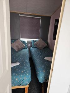 una piccola stanza con due letti e una finestra di Beautiful Mobile Home a Tralee