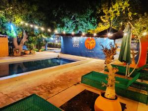 Una piscina de noche con luces y árboles. en Hôtel Les Palmiers, en Ouagadougou