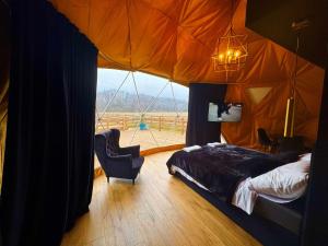 a bedroom with a bed and a large window at Glamping LA BELLA Suntago in Aleksandria