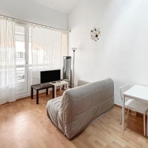 a living room with a couch and a table at Pied-à-terre idéal entre mer et port in Mauguio