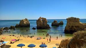 a group of people on a beach with umbrellas at Villa in Salgados Golf - Albufeira in Guia