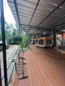 a large tent with a wooden floor and a table and chairs at Cabin rahong riverside in Palayangan