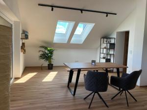 a dining room with a table and two chairs at Sunset am Attersee in Nussdorf am Attersee