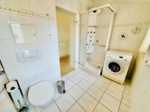 a bathroom with a toilet and a washing machine at Sonnenaufgang, direkt am Alten Strom in Warnemünde +13 photos