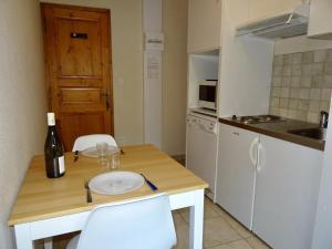 cocina con mesa y botella de vino en Les Oulles 17, en La Chapelle-en-Valgodemard