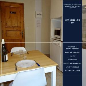 una mesa con dos sillas y una botella de vino en Les Oulles 17, en La Chapelle-en-Valgodemard