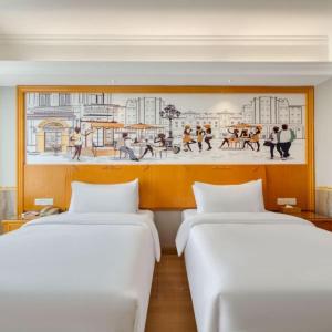 two beds in a room with a painting on the wall at Vienna 3 Best Hotel Fuzhou Fuma Road Ziyang in Fuzhou