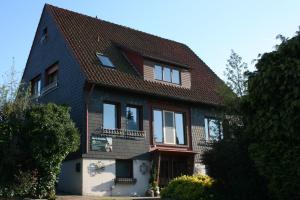 a house with a dog sitting on the balcony at Guest House Am Sonnenwinkel in Schledehausen