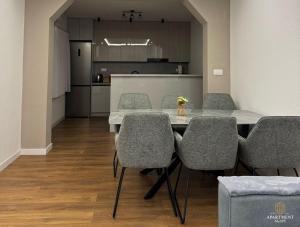 a dining room with a table and chairs and a kitchen at Apartment Agape in Posušje