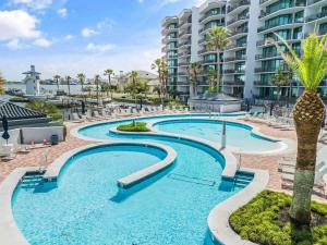 オレンジビーチにあるVilla Grandeのヤシの木が立ち並ぶ建物の前のスイミングプール