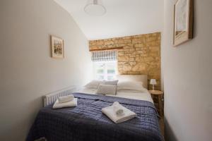 ein Schlafzimmer mit einem Bett mit Handtüchern darauf in der Unterkunft Tilly's Cottage in Bourton on the Water