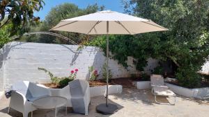 a table and two chairs and an umbrella at Modern Summer House Kalimera in Epanomi