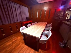 a conference room with a wooden table and chairs at GRAND HOTEL SHISA St OKINAWA グランドホテル シーサーストリート沖縄 in Urasoe
