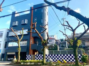 a blue building with trees in front of it at GRAND HOTEL SHISA St OKINAWA グランドホテル シーサーストリート沖縄 in Urasoe