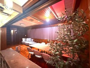 a dining room with a table and a couch at GRAND HOTEL SHISA St OKINAWA グランドホテル シーサーストリート沖縄 in Urasoe +74 photos