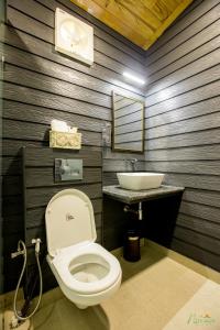 un bagno con un water e un lavandino di Nirmaya Resort a Kanatal