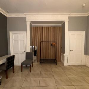 a room with two doors and a table and chairs at Spacious Double Room In The Heart Of Edinburgh in Edinburgh