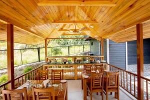 a restaurant with wooden ceilings and wooden tables and chairs at Nirmaya Resort in Kanatal