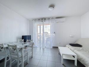 ein weißes Wohnzimmer mit einem Tisch und einer Couch in der Unterkunft 3312-T3 dans une résidence avec piscine in Argelès-sur-Mer