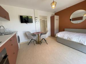 une chambre avec un lit, une table et des chaises dans l'établissement Les gites du champ des oiseaux, à Saint-Amand-les-Eaux