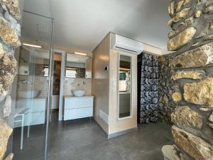 a bathroom with two sinks and a stone wall at IseoLakeRental - Dove il Lago Brilla in Vigolo