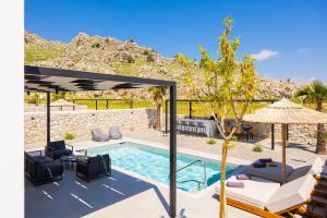 a patio with a pool and chairs and an umbrella at Villa 13 Zendo in Kolymbia