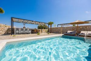 a swimming pool with chairs and an umbrella at Villa 13 Zendo in Kolymbia