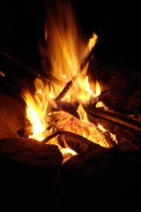 un fuego se quema en una fogata por la noche en Hotel Ráquira Silvestre Lodge, en Tinjacá
