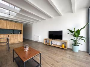 a living room with a table and a flat screen tv at loft en el centro in Vilanova i la Geltrú +10 photos