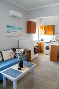 Una sala de estar con un sofá azul y una mesa. en Nefeli Rooms, en Agia Marina de Nea Kydonia