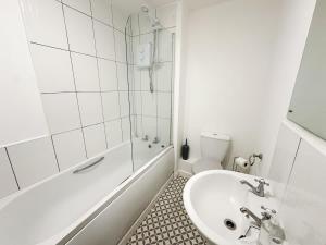 a bathroom with a sink and a tub and a toilet at Edison House by Blue Skies Stays in Stockton-on-Tees