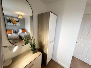 a mirror in a room with a bed and a bedroom at Edison House by Blue Skies Stays in Stockton-on-Tees