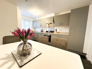a vase of flowers sitting on a table in a kitchen at Curlew Place by Blue Skies Stays in Stockton-on-Tees