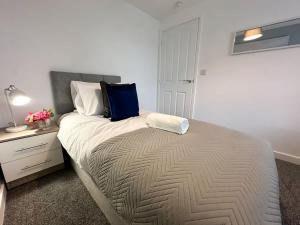 a bedroom with a bed with a blue bag on it at Curlew Place by Blue Skies Stays in Stockton-on-Tees