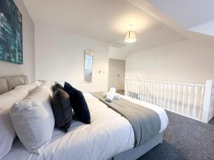 a bedroom with a large white bed with black pillows at Curlew Place by Blue Skies Stays in Stockton-on-Tees +16 photos