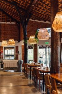 a dining room with tables and chairs and chandeliers at Hotel Jardín del Paraná in Paso de la Patria