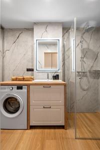 a bathroom with a sink and a washing machine at ApartHouse 45B in Radomierzyce