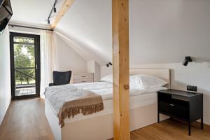 a bedroom with a bed and a desk and a window at ApartHouse 45B in Radomierzyce