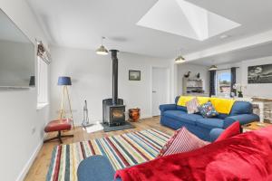 a living room with a blue couch and a fireplace at The Old Workshop - North East Escapes in Wooler