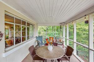 una veranda riparata con tavolo e sedie di Lake Chatuge Cottage a Hiawassee Altre 17 foto