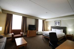 a hotel room with a bed and a television at Waterloo Suites Hotel, Trademark Collection by Wyndham in Waterloo