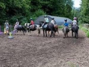 a group of people riding horses on a dirt field at Charmant T3 avec Jardin, Parking, et Cuisine Équipée à Saint-Jean-d'Aulps - FR-1-573-130 in Saint-Jean-dʼAulps