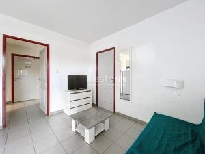 een woonkamer met een tv en een bank bij 3313-Appartement 8 couchages avec piscine in Argelès-sur-Mer